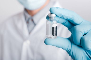 Doktorlar cerrahi maske ve gözlük takıyor, bilim adamları, bilim adamları COVID-19 için şırınga ve aşı, aşı ve laboratuvar deneyleri tutuyor. Virüs koruma kavramı COVID-19,