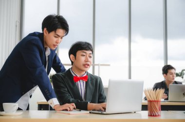 Bir grup genç iş adamı, ofiste gülümseyen meslektaşlarıyla masalarında oturuyor. İş adamlarıyla tanışmak, konsept planlamak, dizüstü bilgisayar buluşması fikirleri. İşine odaklan. LGBT takım çalışması.