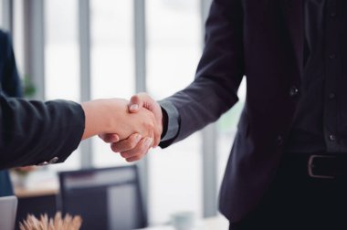 Takım elbiseli bir iş adamı iş ortaklığı anlaşmasını kabul etmek için tokalaşıyor. İş adabı tebrikleri, ofis toplantısı sırasında el sıkışma kavramı..