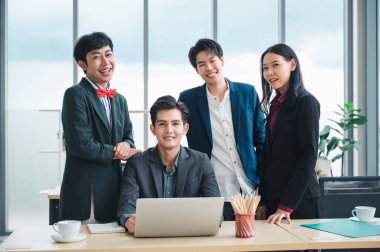 Kendine güvenen ve zeki LGBT iş adamlarından oluşan bir grup resmi giyinmiş kişiler masalarında otururlar. Arka planda bir laptop var. Rahatlama kavramı. Çeşitlilik, ırk ve kültür kavramı.