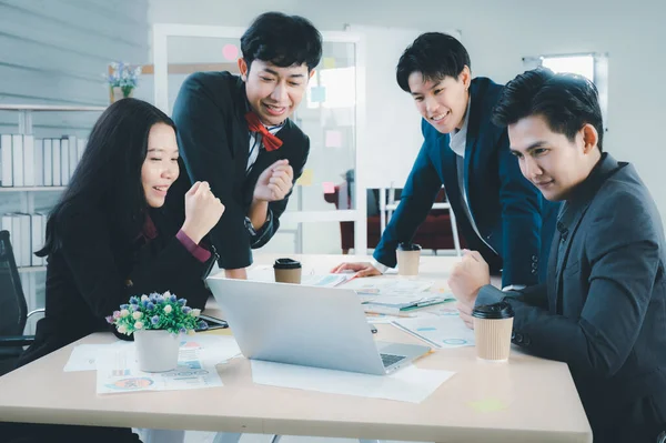 Group of young business people sit at their desks with smiling colleagues together in the office.  Meeting business people  planning concept, laptop meeting ideas. Concentrate on work. LGBT teamwork.