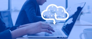 Businessman working at cloud data icon, a man sitting on a wooden table and using a contemporary laptop by the window. Concept of close-up of a hand printed on a laptop.