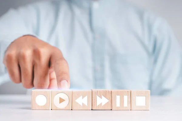 People touch the wood blocks with their index fingers. With a music player button to select a play icon