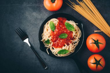 Domates soslu spagetti, kıyma, parmesan peyniri ve fesleğen arkaplanı. Üst görünüm kopyalama alanı.