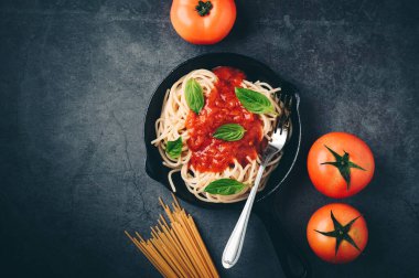 Domates soslu spagetti, kıyma, parmesan peyniri ve fesleğen arkaplanı. Üst görünüm kopyalama alanı.