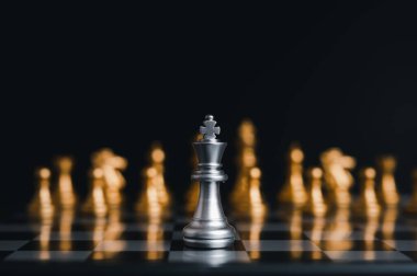 Gümüş kral satranç tahtası yarışmasında gümüş satranç taşlarıyla çevrili. Konsept stratejisi, liderlik ve başarı işi..