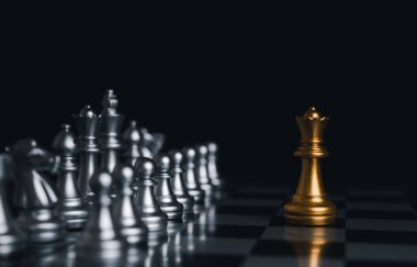 Satranç tahtası yarışmasında gümüş satranç taşlarıyla çevrili altın kral kazandı. Konsept stratejisi, liderlik ve başarı işi.