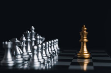 Satranç tahtası yarışmasında gümüş satranç taşlarıyla çevrili altın kral kazandı. Konsept stratejisi, liderlik ve başarı işi.