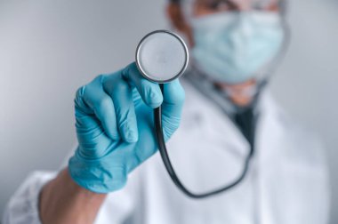 Doktorlar cerrahi maske ve gözlük takıyor, bilim adamları COVID-19 için şırınga ve aşı tutuyor. Aşı ve laboratuvar deneyleri. Virüs koruma kavramı COVID-19.