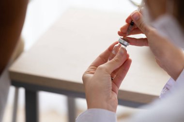 Doktor ya da bilim adamı COVID-19, aşı ve laboratuvar deneylerine karşı bir şırınga ve aşı taşıyor. Koronavirüse karşı koruma kavramı.