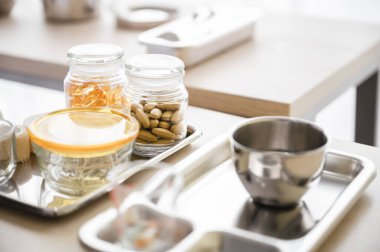 Ek kapsüllerin şişesi bulanık bir arka planla bir masanın üzerindeki tepsiye yerleştirilir. Sağlık hizmeti kavramı.