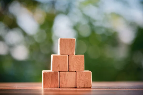 Wood block stacking as step stair to show concepts to strategy business growth to success with natural green background.