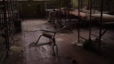 2020 yılında Ukrayna 'nın Çernobil sınırlama bölgesindeki Pripyat hayalet kasabasında terk edilmiş bir anaokulunda bebek karyolası ve çocuk bisikleti.