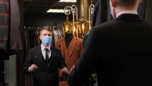 男人摘下镜子前的面具 深深地吸了口气 英俊的男人摘下面罩以保护自己不受科维德 19的感染 奢侈品男装商店的商人 — 图库视频影像