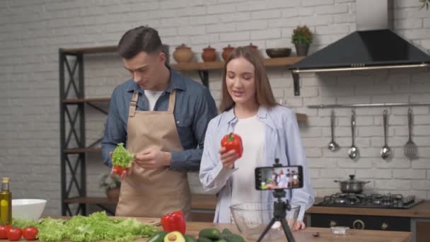 年轻迷人的夫妻博客在家里厨房里拍摄关于烹饪的视频食物博客 健康食品烹调概念 — 图库视频影像