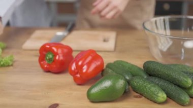 Şefler taze sebzeli salata pişirmek için sebze hazırlıyorlar. Marul, biber, salatalık ve avokado.