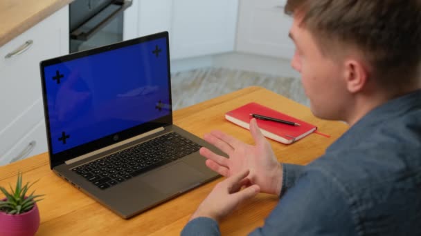 男は同僚と話すスマート男のビューを左にしながらビデオ通話をラップトップ上でクロマキー画面で自宅で近い仕事をしながら — ストック動画