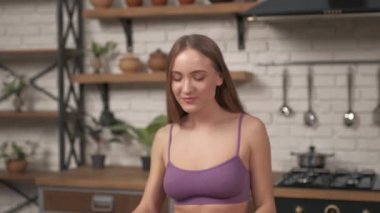 Ev mutfağında ıspanak yiyen genç ve güzel bir kadın. Lezzetli, sağlıklı organik yiyecekler..