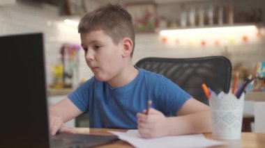 Çevrimiçi öğrenim eğitimi konsepti. Öğretmeni olan çocuk çocuk okul ödevi yazmak ve evde çalışmak için bilgisayarını tablet bilgisayar kullanıyor..