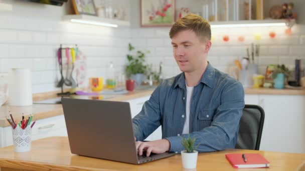 Homme d'affaires souriant entrepreneur tapant sur ordinateur portable faire de la recherche. Jeune professionnel masculin utilisant un ordinateur assis à la maison bureau. Travailleur indépendant occupé travaillant sur un appareil portable technologique moderne. — Video