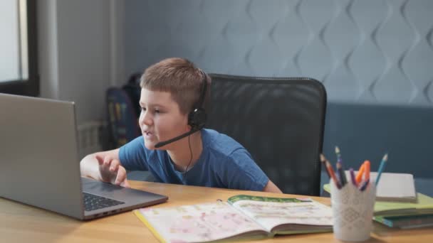 Portret młodego chłopca prowadzącego lekcje online na odległość za pomocą laptopa i internetu za pośrednictwem czatu wideo. Uczenie się na odległość w domu. — Wideo stockowe