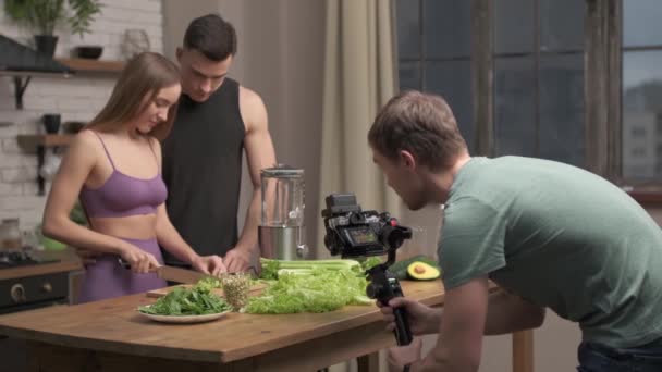 摄影师拍摄厨房场景。恋爱中的夫妻在家里厨房准备健康的饭菜 — 图库视频影像