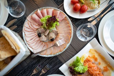 Partiden önce restoranda gümüş çatal bıçak ve cam kadehlerle yemek masası seti servisi. Tabaklarla servis edilir.