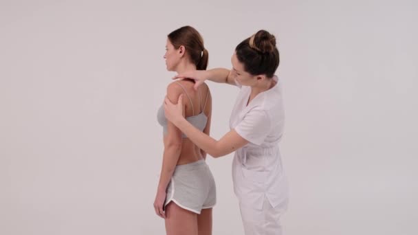 Terapis menerapkan rekaman kinesio pada tubuh wanita. Konsep fisioterapi dan kinesiologi. — Stok Video
