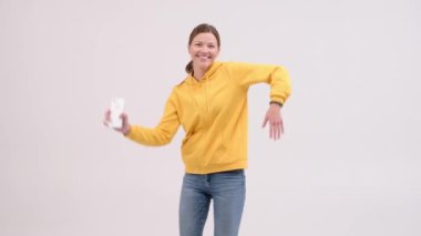 Neşeli Kadın Portresi ellerini oynatmak için ritmik bir şekilde müzik eşliğinde gülümsüyor. İnsanların Olumlu Duyguları. Özgürlük