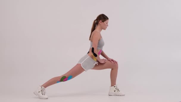 Fit ženy s kinesiotopií na její tělo dělá fitness a protahování. Zdravotní a fitness koncept. — Stock video