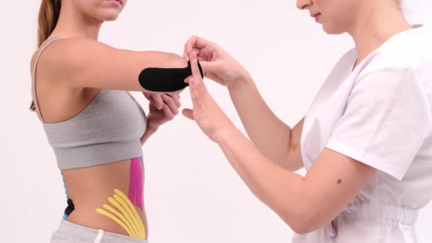 Professionele lijm tapes op een elleboog van een vrouw. Jonge fitte vrouwen tonen op haar elleboog aangebracht elastische kinetische tape. — Stockvideo