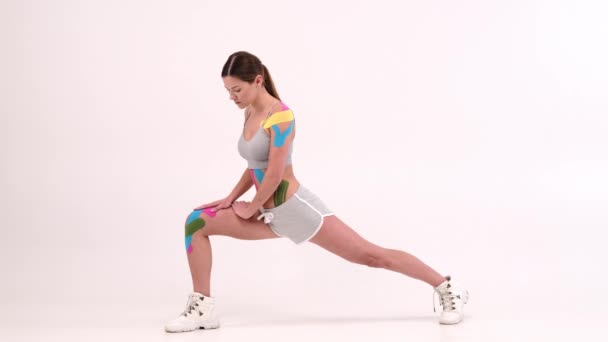 Pełnowymiarowe Portrety Kobiet Sportowców Kinezjotapą Ciele Wykonujących Ćwiczenia Fitness Rozciągających — Wideo stockowe