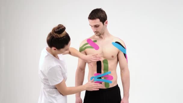 Therapeutin Die Kinesiologie Klebeband Auf Den Bauch Eines Mannes Auf — Stockvideo