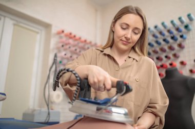 femail Terzisi ütü buharı kullanıyor. Buhar jeneratörü. Moda tasarımcısı stüdyosunda kumaş ütülüyor. Küçük işletme kavramı