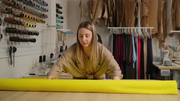 Primer Plano Del Diseñador Femenino Desenrollando Gran Rollo Amarillo Tejido — Vídeos de Stock