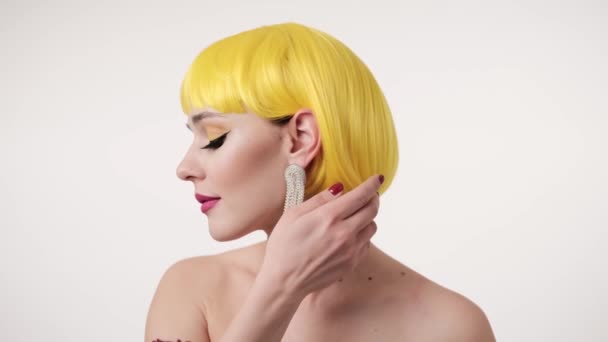 Szekrény portré a nő színes smink futurisztikus stílusban viselő sárga paróka világos háttér. — Stock videók