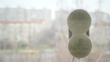 Evcil robot asistan cam pencereyi temizliyor. Yüksek binadaki elektrikli süpürge temizleme penceresi. Şehir ve bina geçmişi