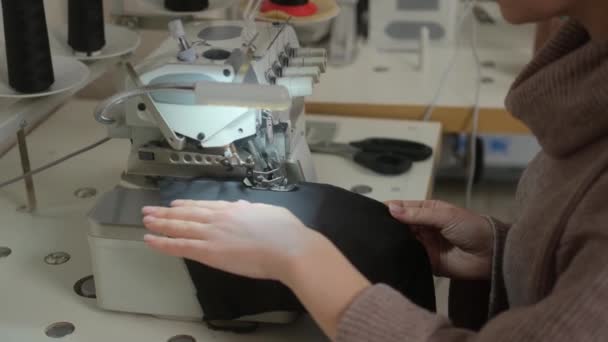 재봉 작업장. 유통 기한내에 제품의 가장자리를 처리하는 거죠. 지그재그 기계꿰매기. 옷감 안감. 공업용 재봉틀에 바느질하는 여자. 잠금 장치 — 비디오