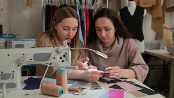 Два Модельєри Дивляться Зразки Тканини Біля Швейної Машини Швейній Майстерні — стокове відео