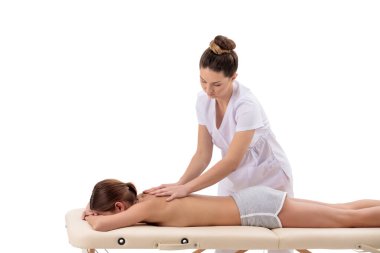 Bayan masör, sırt masajı yapıyor. Genç bayan, portatif masaj masasında yalnız.