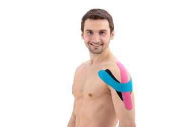 Beyaz arka planda izole edilmiş, fizyolojik bantlı bir erkek omuz. Üzerinde Kinesio bandı olan bir adamın portresi.