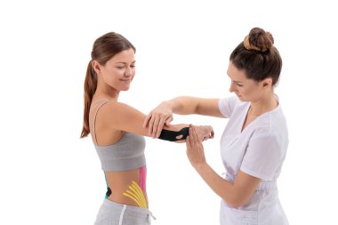 Physiotherapist applying kinesio tape on female patient's arm. Kinesiology, physical therapy, rehabilitation concept. Tennis or golfers elbow treatment. isolated on white background clipart