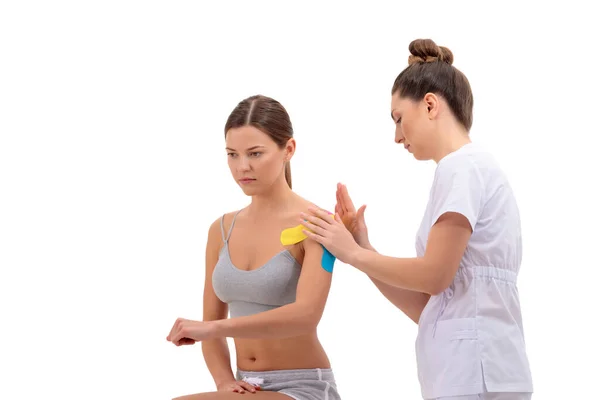 Physiotherapist Putting Kinesio Tape Female Patients Shoulder Isolated White Background — Stock Photo, Image