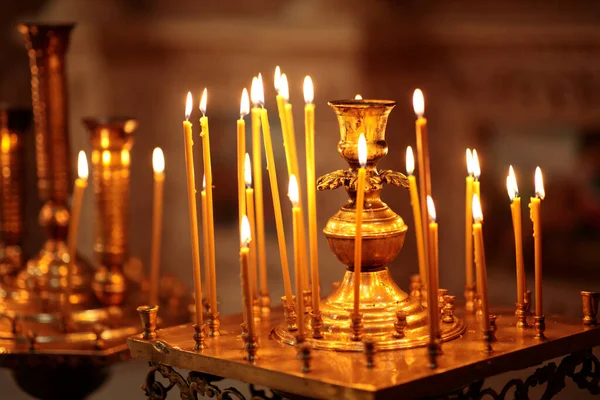 Muchas velas ardientes largas durante el servicio de la iglesia —  Fotos de Stock