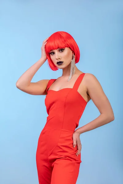 Ritratto di bella donna sexy in parrucca rossa su sfondo blu. — Foto Stock