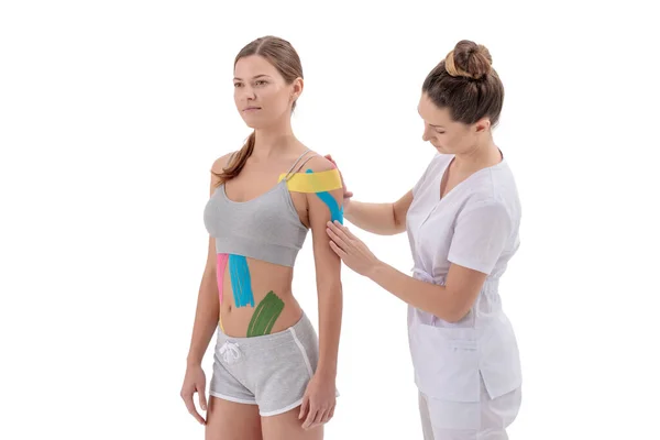 Physiotherapeutin legt Kinesiotape auf die Schulter von Patientinnen — Stockfoto