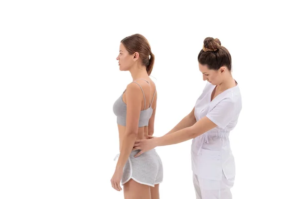 Fisioterapeuta aplicando cinta de kinesio a pacientes femeninas de la espalda baja. Kinesiología, fisioterapia, concepto de rehabilitación. —  Fotos de Stock