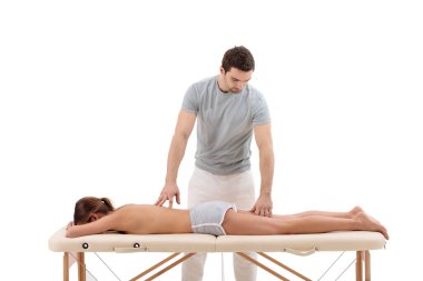 Erkek masör koltukta masör müşterisinin ayaklarına masaj yapıyor.
