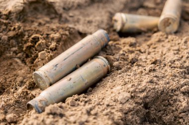 Boş karabina ya da büyük kalibreli tüfek mermileri yakın çekim. Çok sayıda vaka. Silahlı çatışmayı göstermek için pirinç mühimmat fişeklerinin arka planı