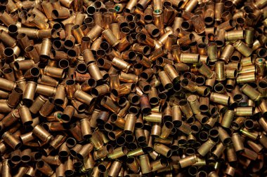 Arka planda bir sürü mermi kovanı var.